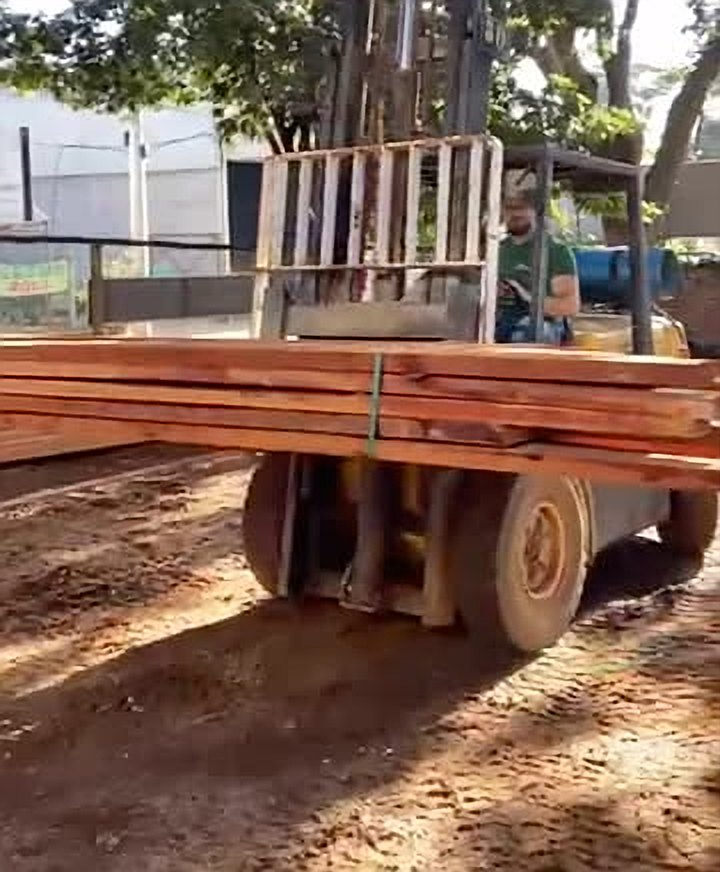 Empilhadeira carregando um lote de madeira serrada para entrega